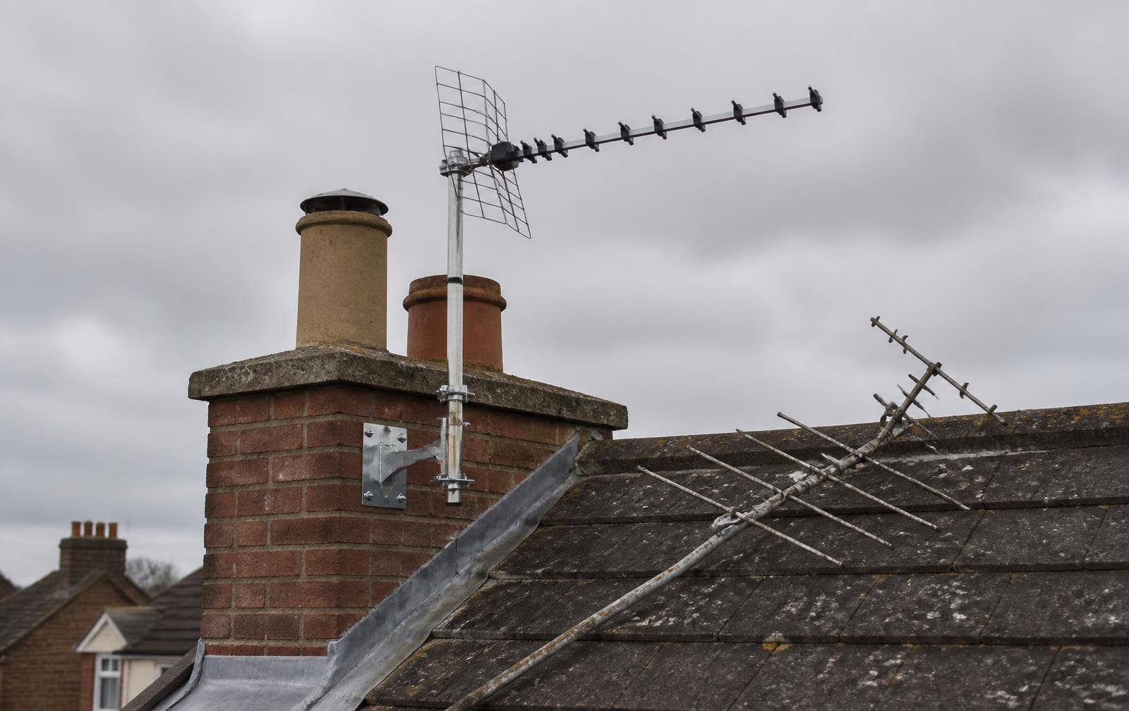 Engineer repairing a storm-damaged aerial on a chimney in Berkshire